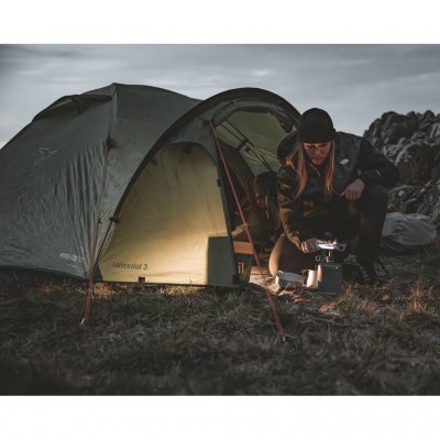 Setesdal 2 kuppeltelte i naturlige omgivelser, én person laver mad foran teltet i mørke med hyggelig atmosfære.