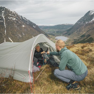 Robens Sprinter 2 LW telt i fjeldmiljø – person modtager udstyr fra indersiden af teltet.