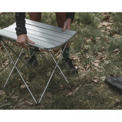 Bordet har en aftagelig bordplade bestående af lameller/plader, der rulles sammen.