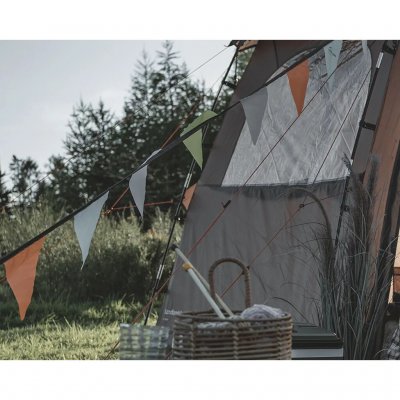 Vimpelguirlande med farverige flag, der skaber feststemning på glamping.