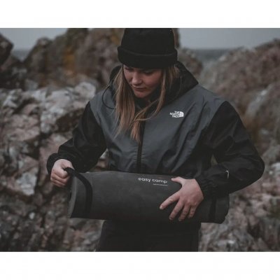 Liggeunderlaget holdes pænt sammenrullet ved hjælp af de to elastiske stropper.